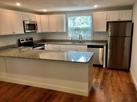 a kitchen with white cabinets and a counter top